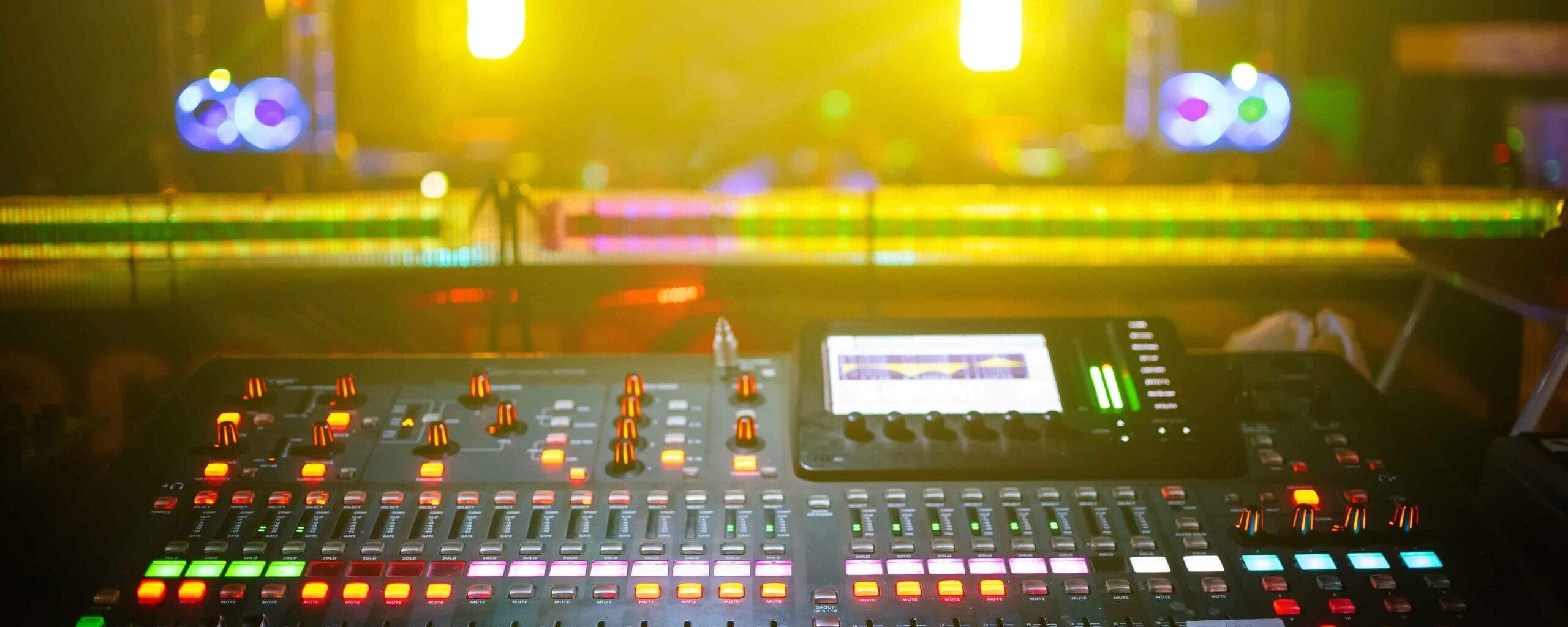 music mixer with stage, concert background blurred, yellow light